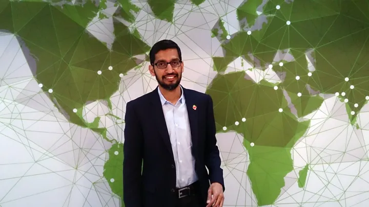 Google CEO Sundar Pichai standing in front of a green network-map backdrop. Photo by Maurizio Pesce, CC BY 2.0, via Wikimedia Commons.